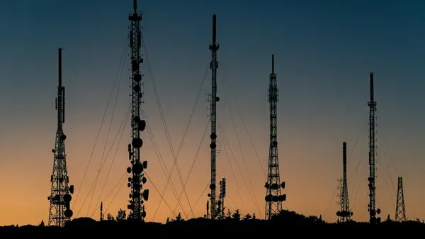 Telecommunications masts silhouetted against a dusk sky.